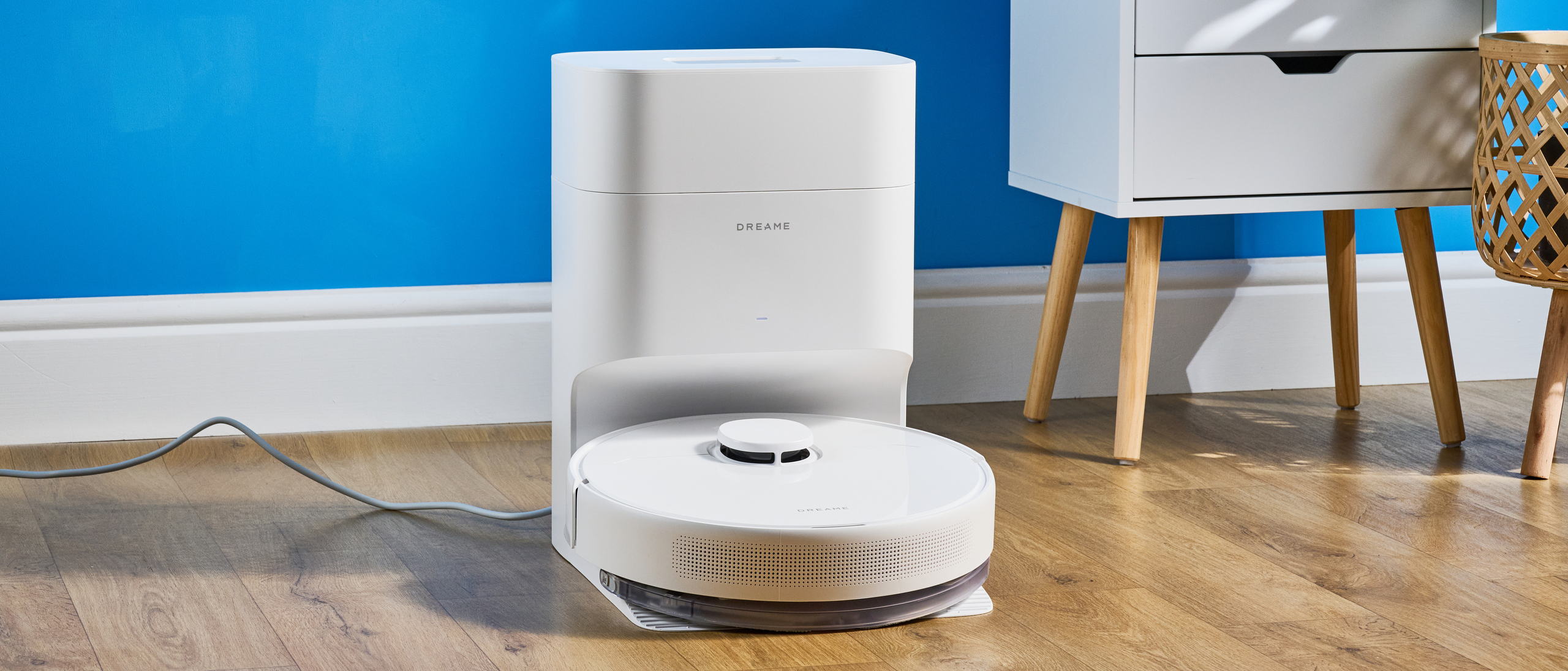 Dreame D10 Plus Gen 2 photographed on a wooden floor in front of a blue backdrop