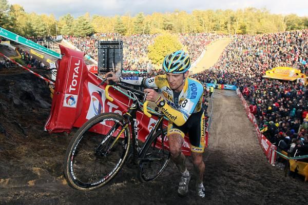 Bart Wellens (Telenet-Fidea) runs with his bike on the sandy Zonhoven parcours