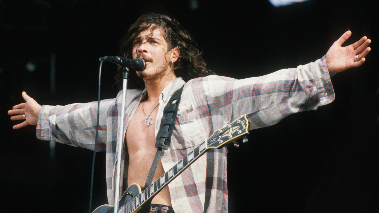 Chris Cornell on stage with his arms outstretched