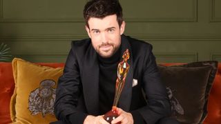 Brit Awards 2026 host Jack Whitehall clutching an award
