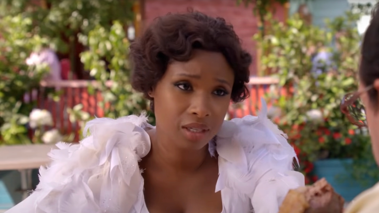 Jennifer Hudson sitting in a chicken costume in a worried conversation in Sandy Wexler.