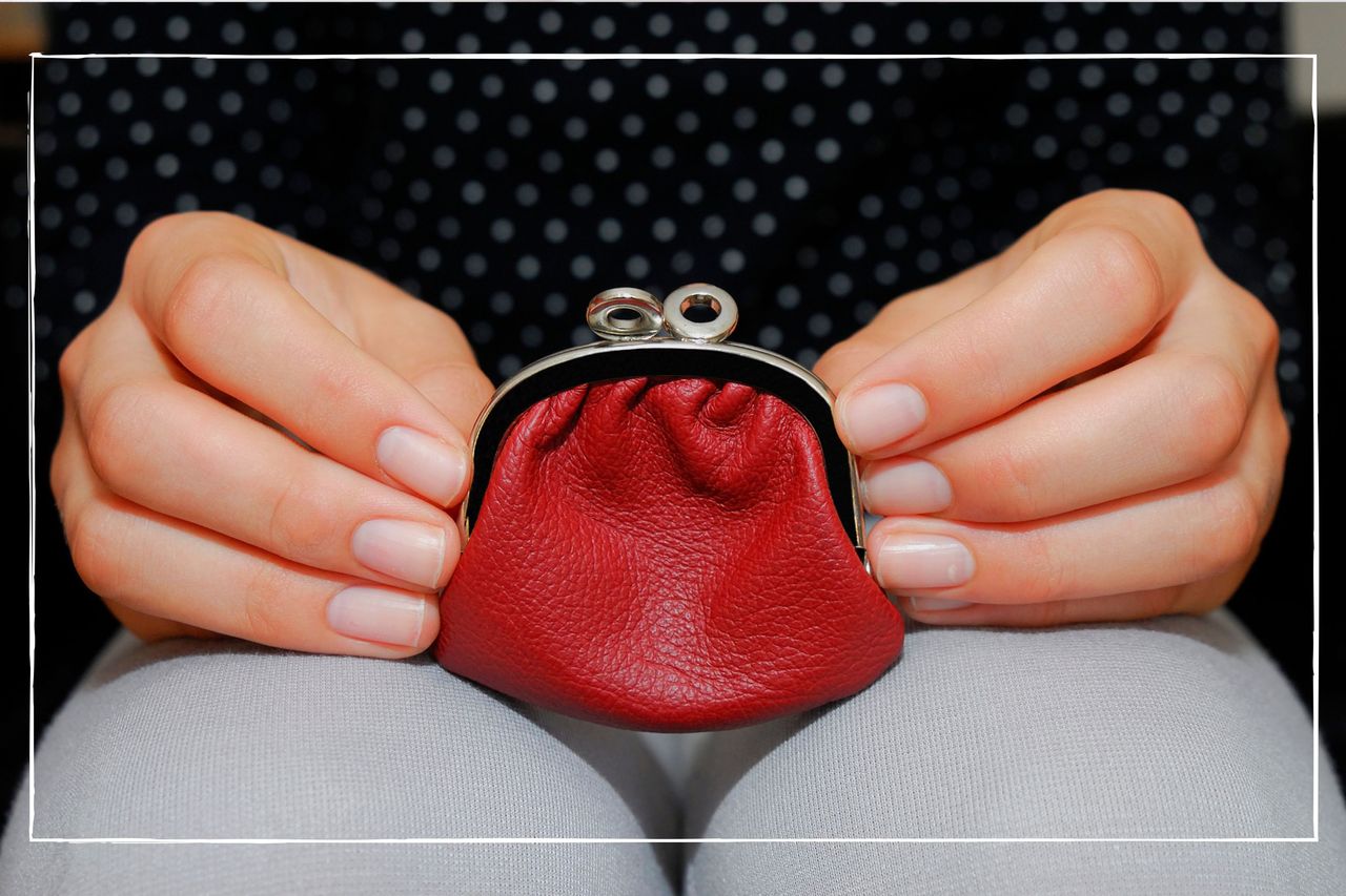 close up of a woman&#039;s hands holding a red coin purse on her lap