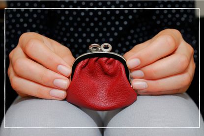 close up of a woman's hands holding a red coin purse on her lap