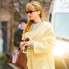 Jennifer Lawrence was spotted in a butter yellow The Row coat, black Alo leggings, Ugg boots, and The Row Lady Bag