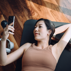 A product shot of a woman working out using one of the best fitness apps on her phone