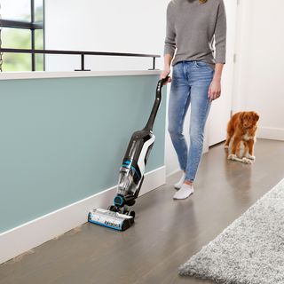 room with wooden flooring white walls and vacuum cleaner
