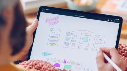 Man using ipad to illustrate Figma design report 2023: State of the Designer