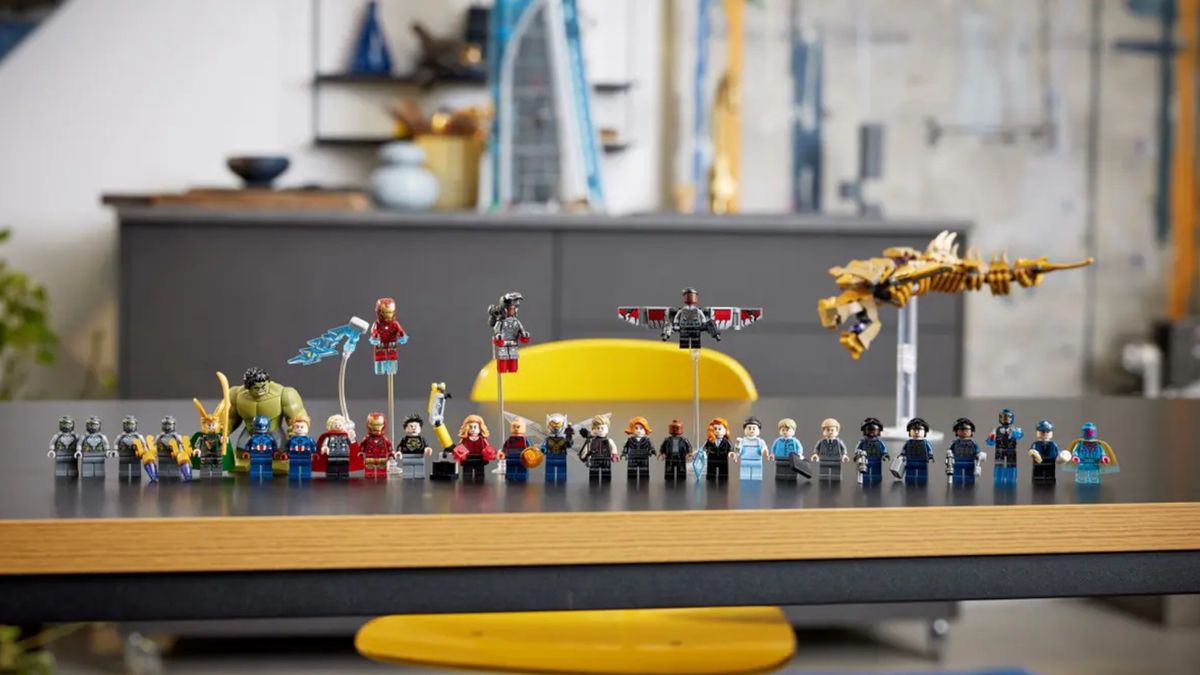 All 31 of the minifigs from Lego Avengers Tower, laid out on a wooden table