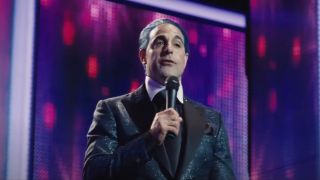 Stanley Tucci presenting his show in front of huge screens in The Hunger Games.