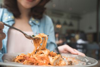 close-up of a woman's hand getting a forkful of spaghetti