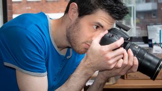 A photographer staring down a camera lens