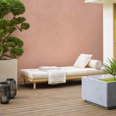 wooden decking with terracotta painted garden wall and large planters