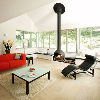 living room with white wall orange sofa suspended log fire and recliner chair