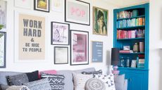 living room with a colourful gallery wall, blue bookcase and grey sofa