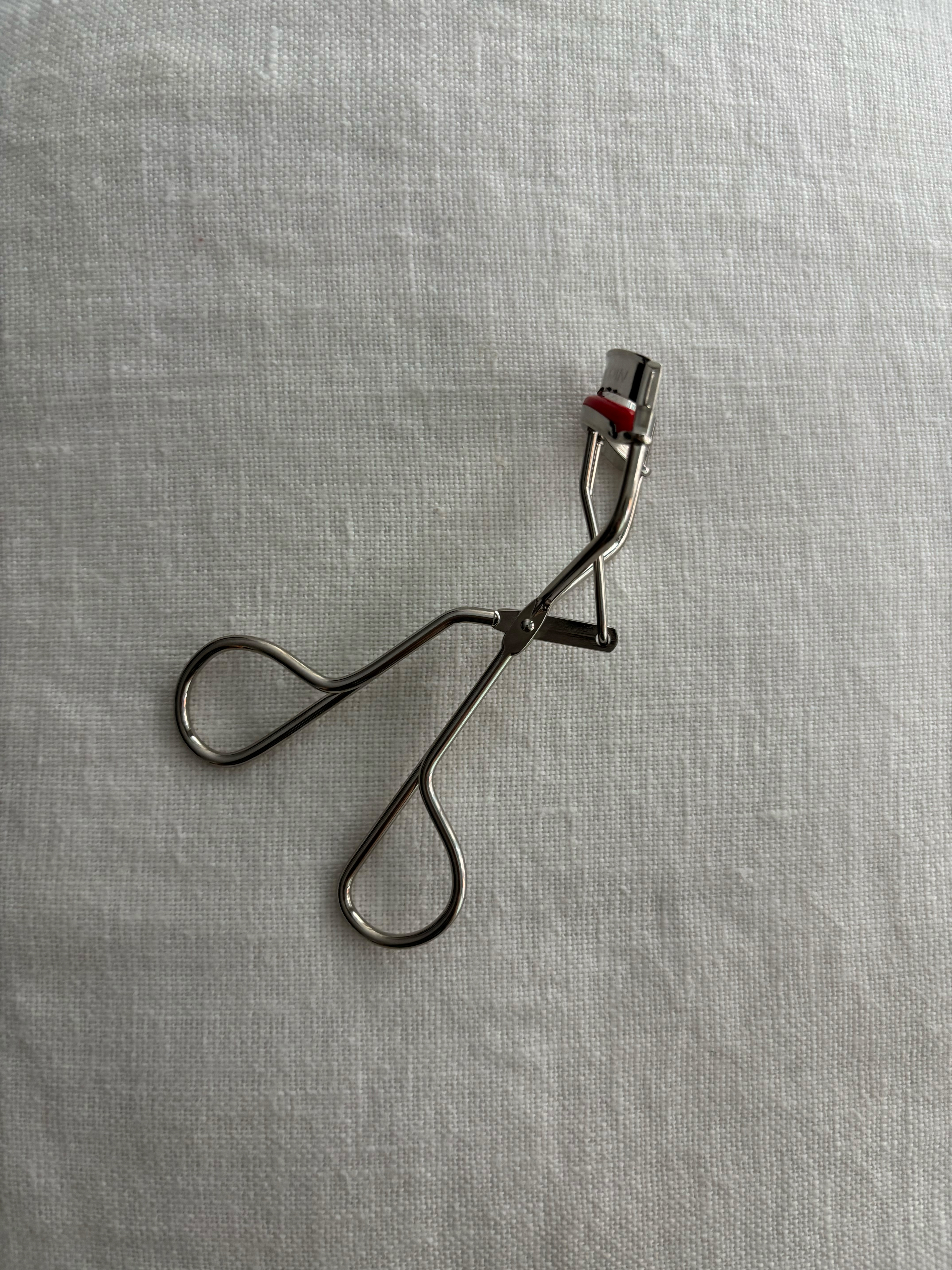 Grace Lindsay holding pair of Kevyn Aucoin eyelash curlers