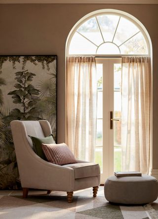 picture of a highback arm chair with cushion and footstool