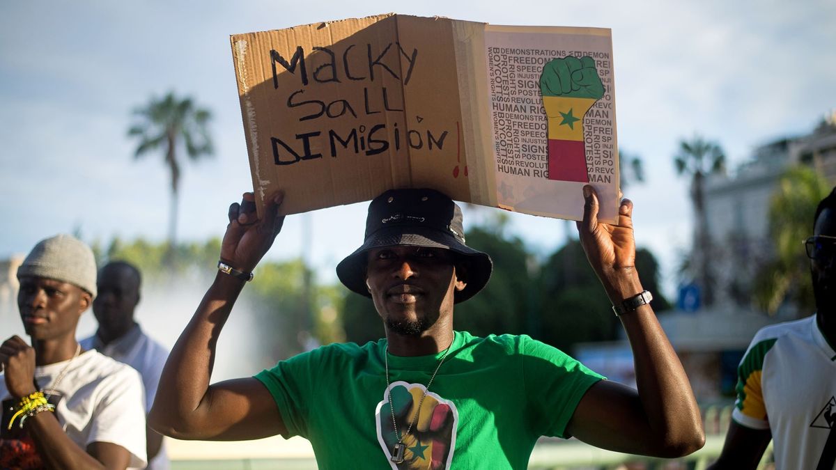 A protester is seen holding a placard during a protest against the dictatorship of Senegal&#039;s current president, Macky Sall, at Plaza de la Marina Square in Malaga