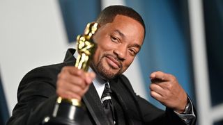 Will Smith holds an Oscar trophy while attending the 2022 Vanity Fair Oscar Party 