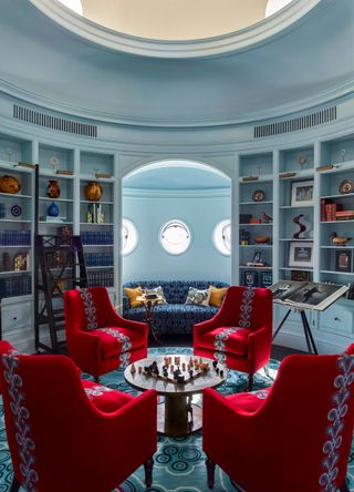 Red armchairs with blue pattern, chess table, blue sofa with light blue pattern