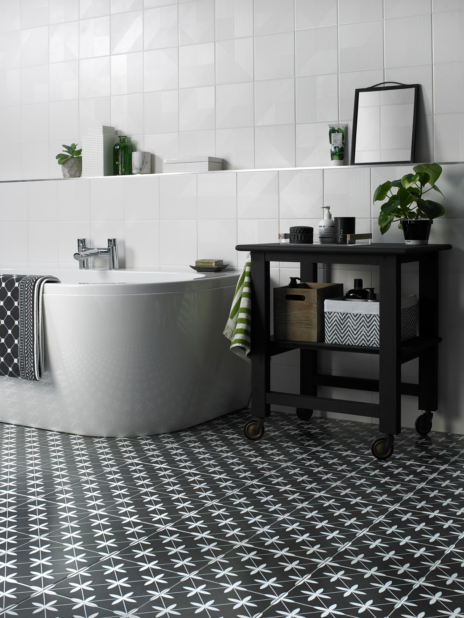 Bathroom with black and white patterned floor, storage unit on wheels