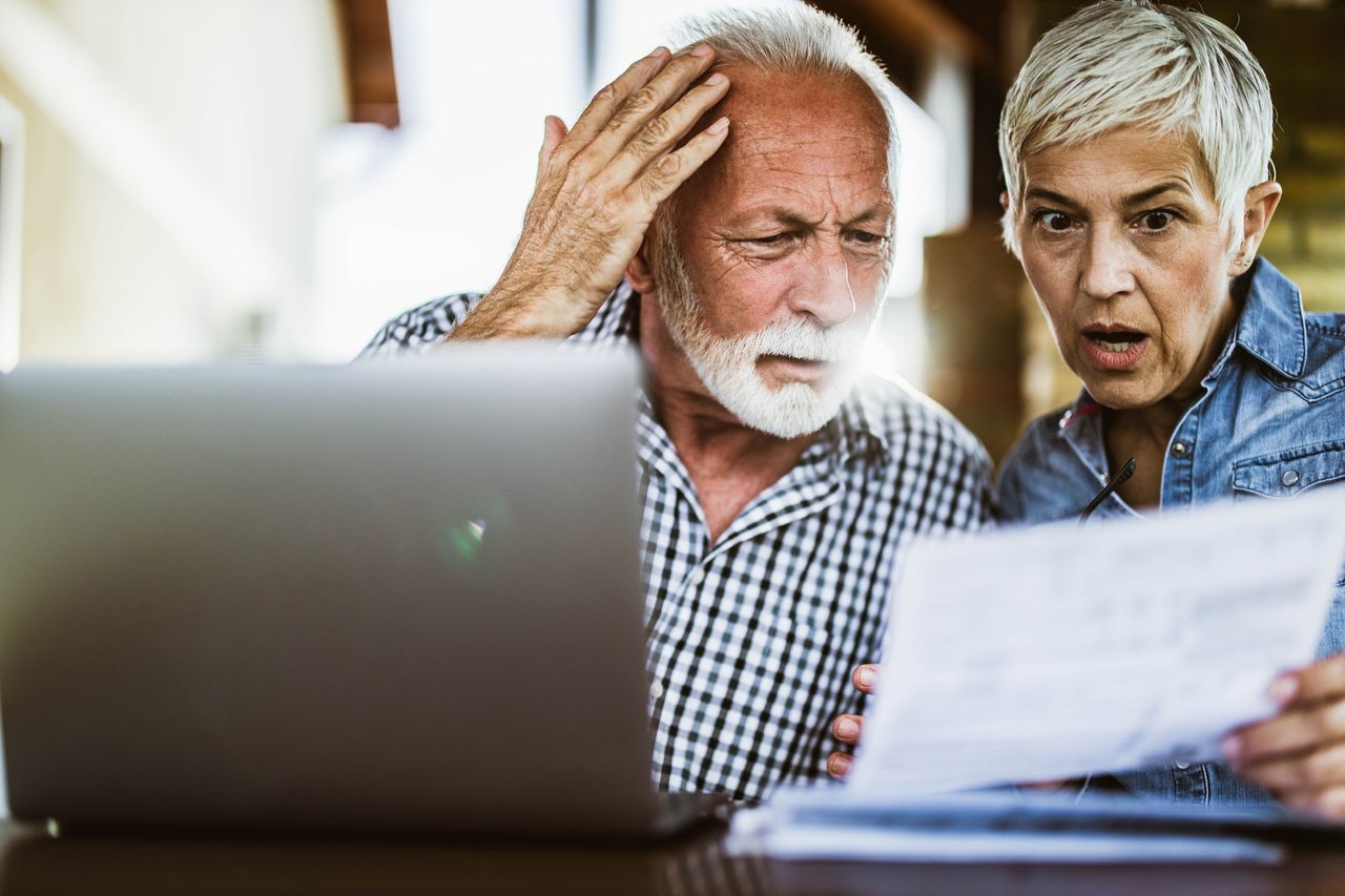 Shocked couple looking at bill