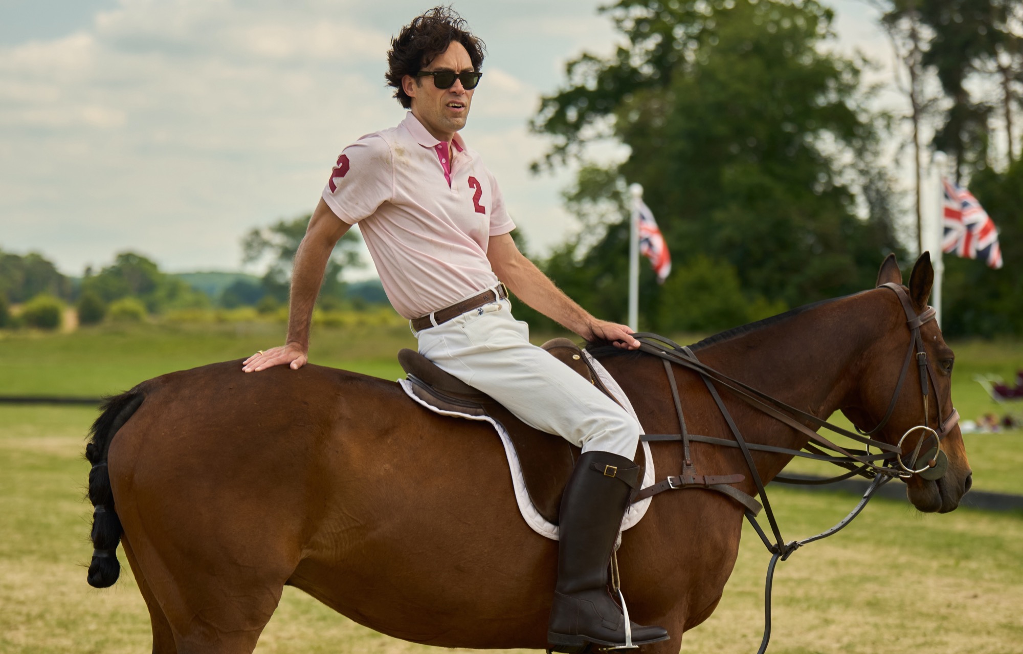 Alex hassell as Rupert Campbell Black, sat on a horse in polo gear
