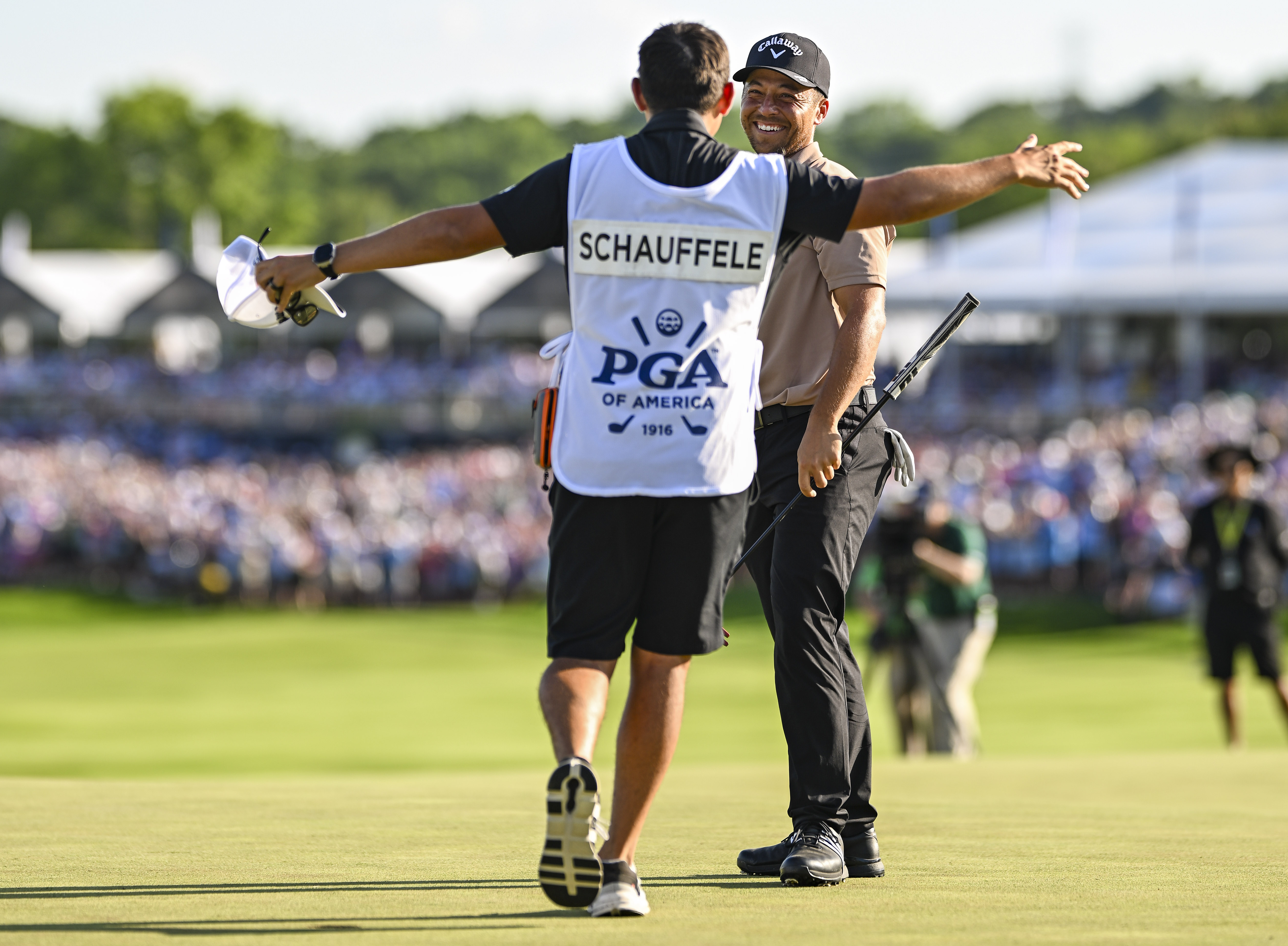 Schauffele's caddie hugs Xander on the 18th hole at the PGA Championship