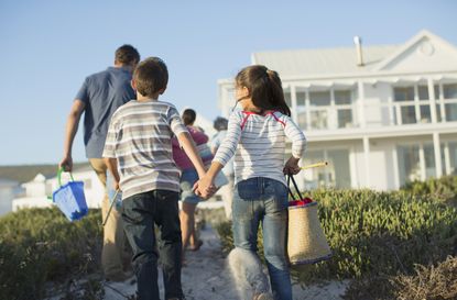 Brother and sister holding hands on beach path