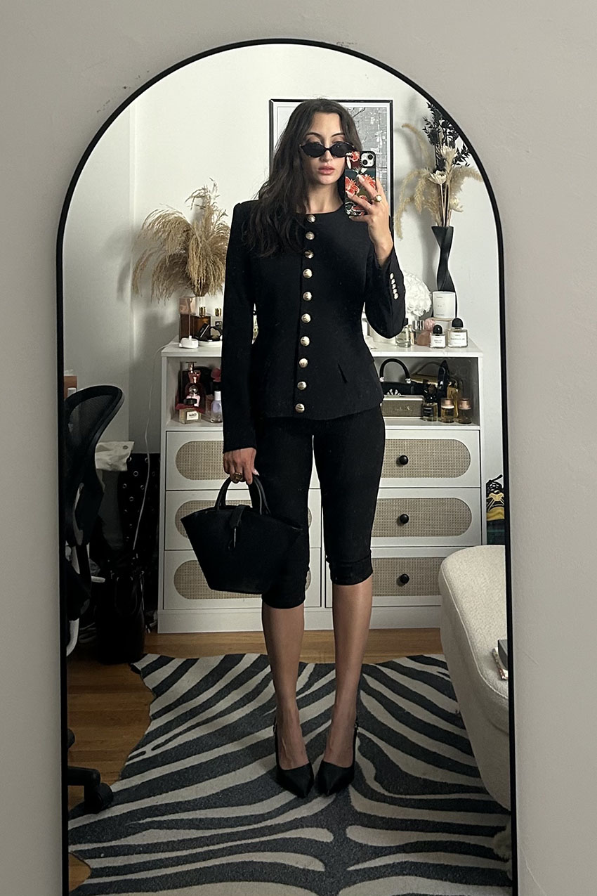 A woman wearing a collarless blazer and capri pants