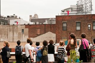 Image of a crowd watching a rooftop dance performance