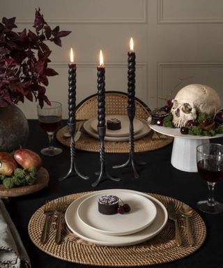 gothic halloween decor tablescape with a skull and black candles