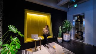 Woman sat in large yellow alcove next to lift