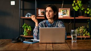 Woman sitting down at desk in front of laptop