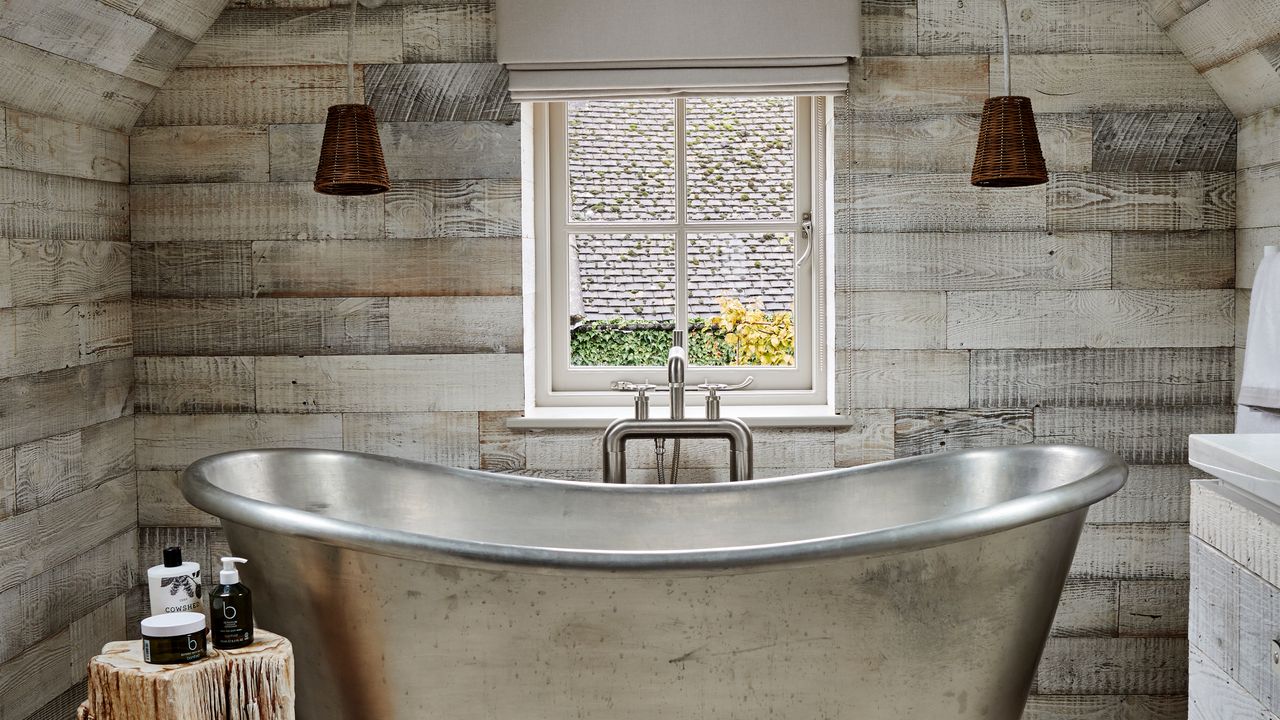 Silver freestanding bath with black wall light shades