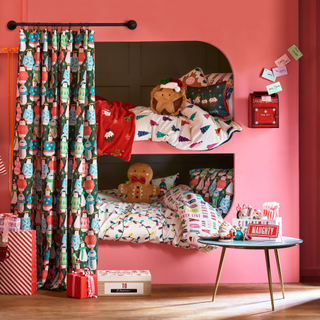 Kids christmas bedroom of built-in painted bunk beds and a festive curtain next to christmas bedding covered beds