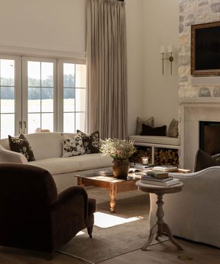 neutral farmhouse living room with two white couches facing each other opposite a stone fireplace