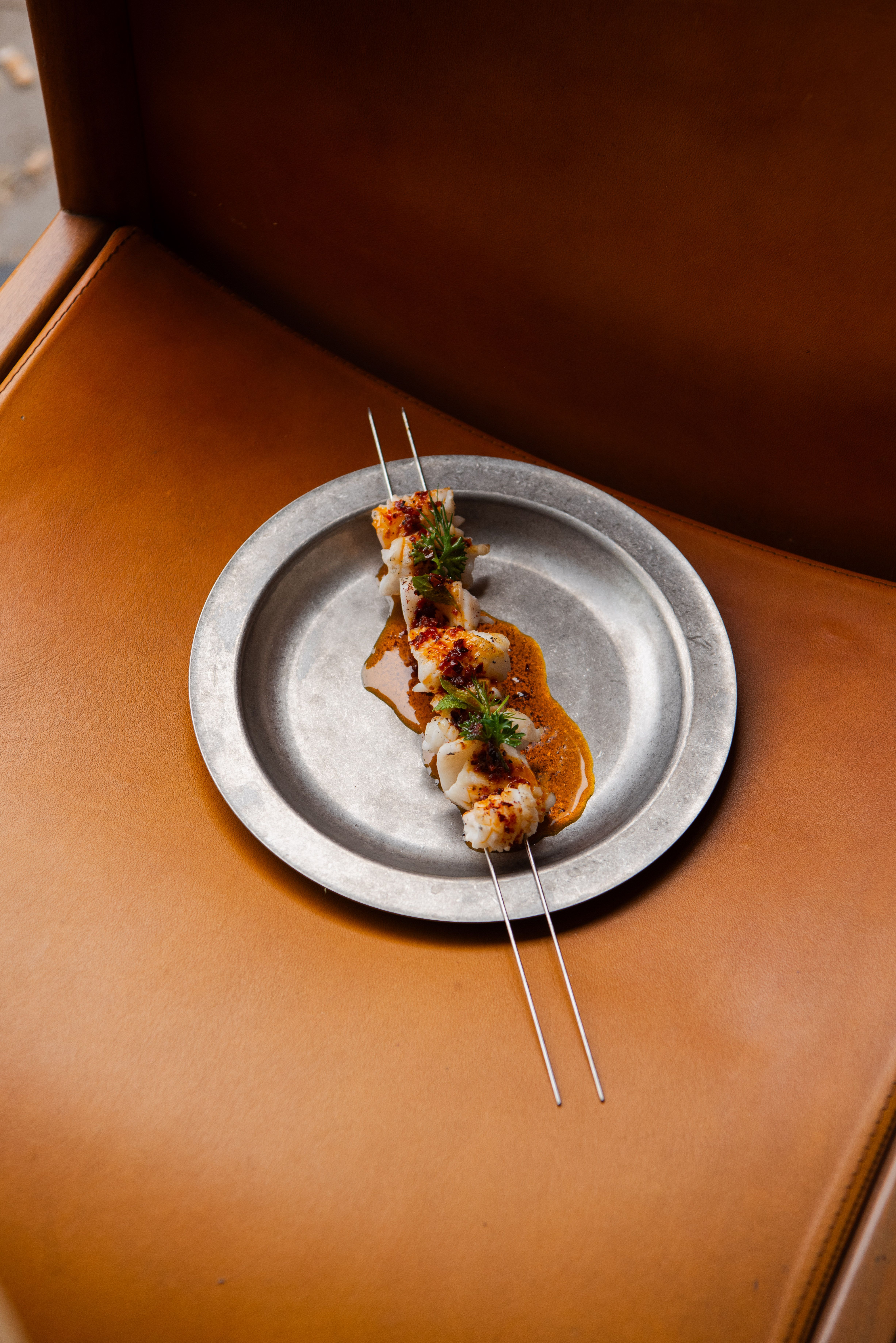 Food and lifestyle shots of a restaurant depict colorful, made-to-share food platters being handled by guests in a warmly decorated, high-end yet playful setting.