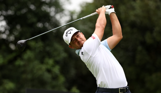 Xander Schauffele hits a driver and watches the flight of it