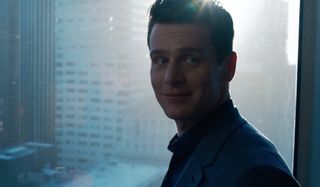 Jonathan Groff looking back with a smile from his office window in The Matrix Resurrections.