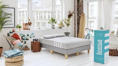 Make the most of the best mattress sales with items like this Leesa original firm mattress in white modern-industrial apartment bedroom on grey bed upholstered bed frame with light wooden legs