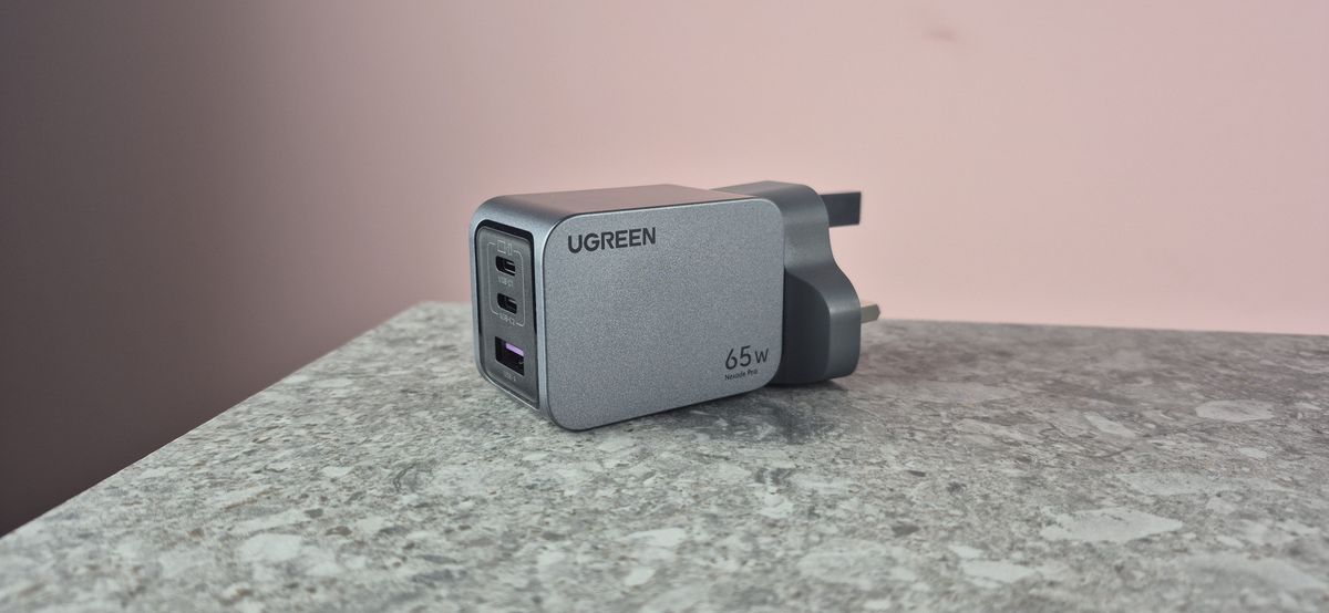 UGreen Nexode Pro 65W 3-Port Charger on stone surface against pink background