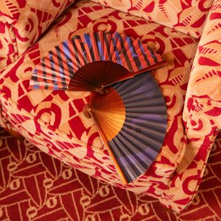 Fans laying on a patterned armchair