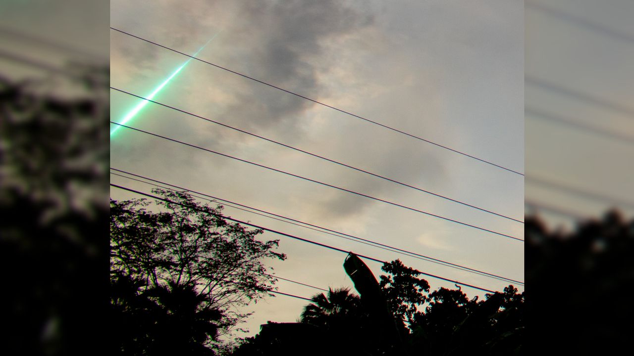 A photo of a green streak of light in the sky