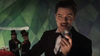 Dominic Cooper smiles as he speaks into a mic in Captain America: The First Avenger.