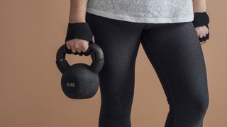 Close up of woman's hand holding a metal kettlebell