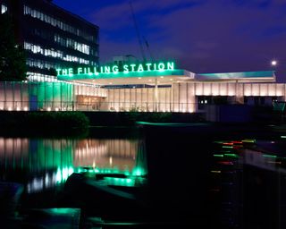 The Filling Station, lit up with neon signage and forecourt lighting