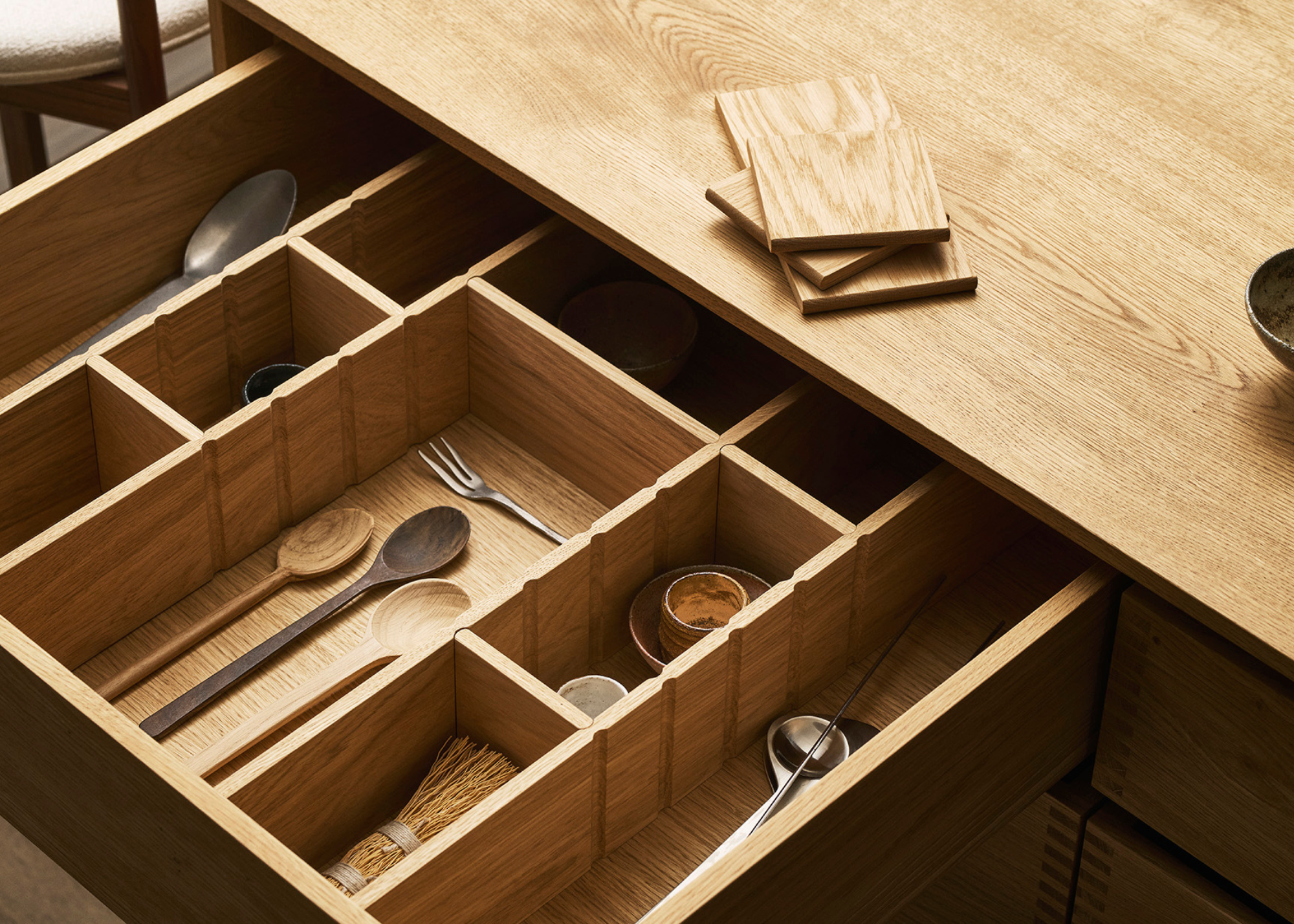 wooden kitchen drawer with custom inserts for cutlery and other utensils