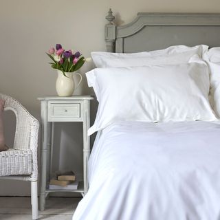 white pillow on bed and lamp on bedside table