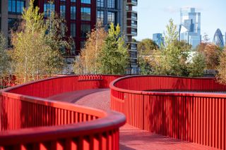 Asif Khan boardwalk at Canada Water bright red bridge across water and natural water wildlife habitat