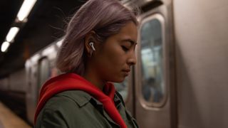 Apple AirPods Pro worn by woman in a train station